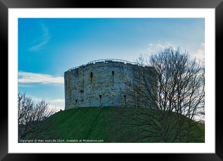 Medieval stone tower on a grassy hill with bare trees against a blue sky with clouds in York, UK. Framed Mounted Print by Man And Life