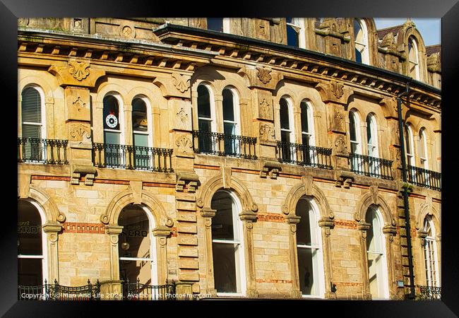 Vintage brick building facade with ornate windows and architectural details under a clear blue sky in Harrogate, England. Framed Print by Man And Life