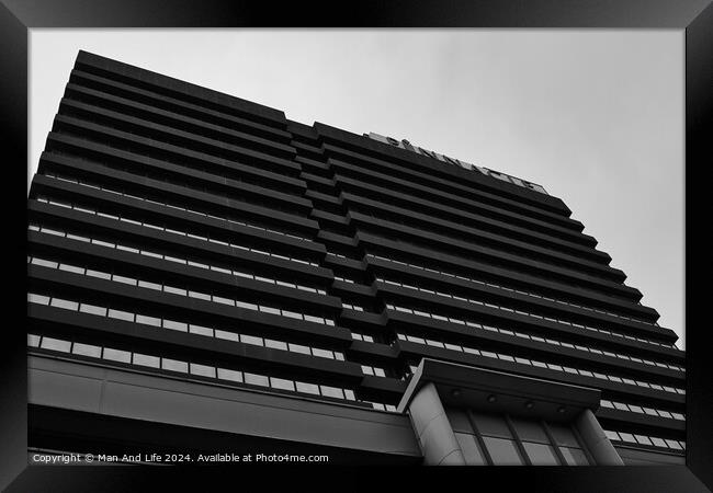 Modern black and white architectural photograph of a high-rise building with a patterned facade against a cloudy sky in Leeds, UK. Framed Print by Man And Life