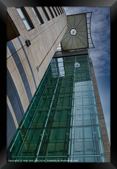 Modern architectural detail with glass facade and clock tower against a blue sky in Leeds, UK. Framed Print by Man And Life