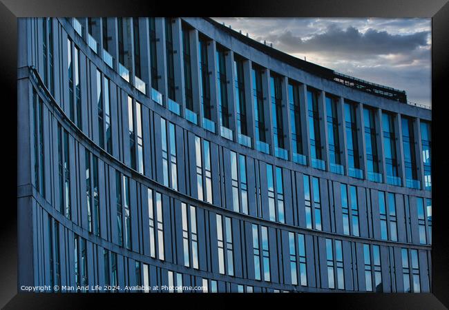 Modern office building facade with reflective glass windows against a cloudy sky at dusk in Liverpool, UK. Framed Print by Man And Life