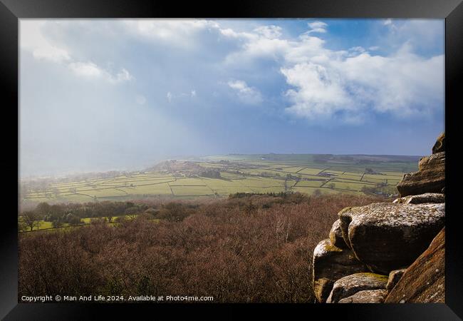 Scenic view of a sunlit countryside landscape with rocky foreground under a dramatic sky at Brimham Rocks, in North Yorkshire Framed Print by Man And Life
