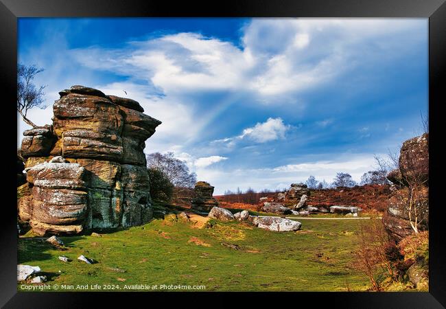 Scenic view of rock formations and lush greenery under a blue sky with wispy clouds at Brimham Rocks, in North Yorkshire Framed Print by Man And Life