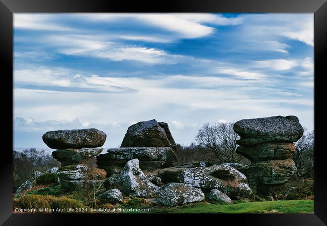 Scenic view of unique rock formations with moss under a cloudy sky in a lush green landscape at Brimham Rocks, in North Yorkshire Framed Print by Man And Life