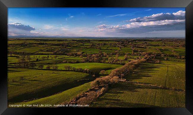 Aerial view of lush green countryside with fields and trees under a blue sky with scattered clouds in North Yorkshire. Framed Print by Man And Life