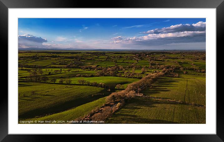 Aerial view of lush green countryside with fields and trees under a blue sky with scattered clouds in North Yorkshire. Framed Mounted Print by Man And Life