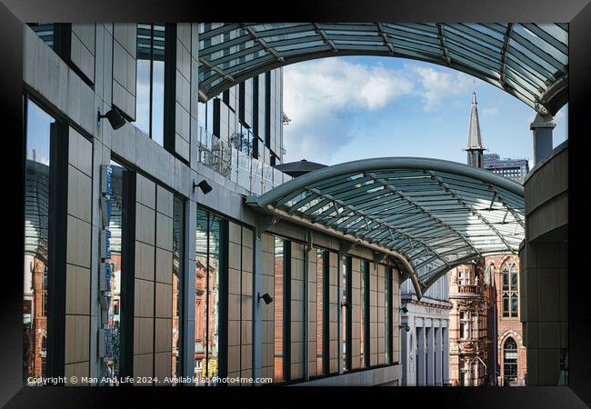 Modern glass-covered walkway with urban architecture and blue sky in the background in Leeds, UK. Framed Print by Man And Life