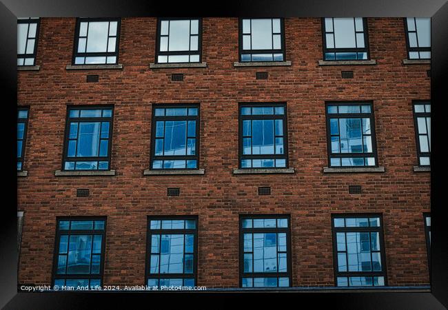 Symmetrical brick building facade with rows of blue windows, urban architecture background in Leeds, UK. Framed Print by Man And Life