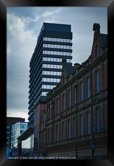 Contrast of old and new architecture with a modern skyscraper towering behind a classic brick building under a cloudy sky in Leeds, UK. Framed Print by Man And Life