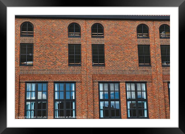 Facade of a vintage brick building with rows of windows reflecting the sky, showcasing industrial architecture in York, North Yorkshire, England. Framed Mounted Print by Man And Life
