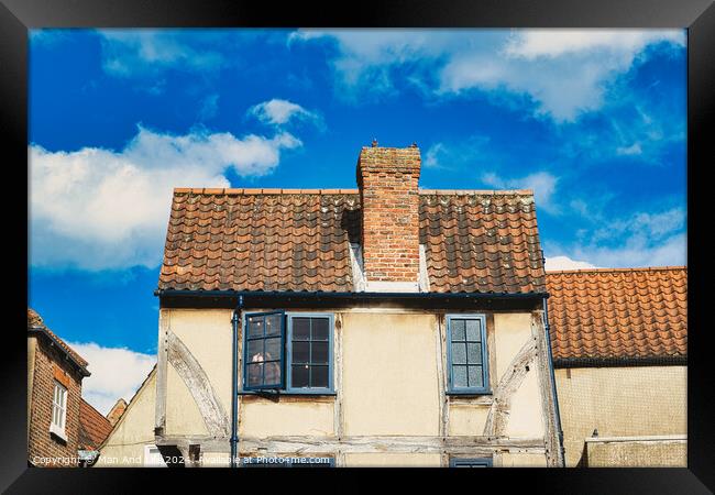 Old European building with weathered facade and terracotta roof tiles against a backdrop of a vibrant blue sky with fluffy clouds in York, North Yorkshire, England. Framed Print by Man And Life