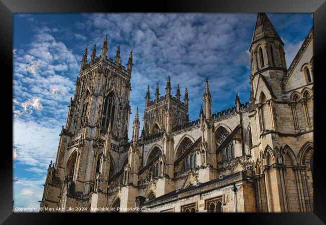 Gothic cathedral tower against a dramatic cloudy sky, showcasing intricate architectural details and spires, ideal for historical or religious themes in York, North Yorkshire, England. Framed Print by Man And Life