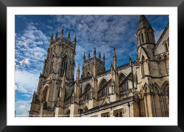 Gothic cathedral tower against a dramatic cloudy sky, showcasing intricate architectural details and spires, ideal for historical or religious themes in York, North Yorkshire, England. Framed Mounted Print by Man And Life