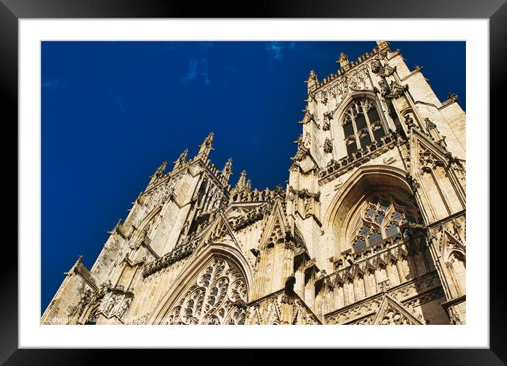 Gothic cathedral facade against a clear blue sky, showcasing intricate architectural details and stone carvings, perfect for historical and travel themes in York, North Yorkshire, England. Framed Mounted Print by Man And Life