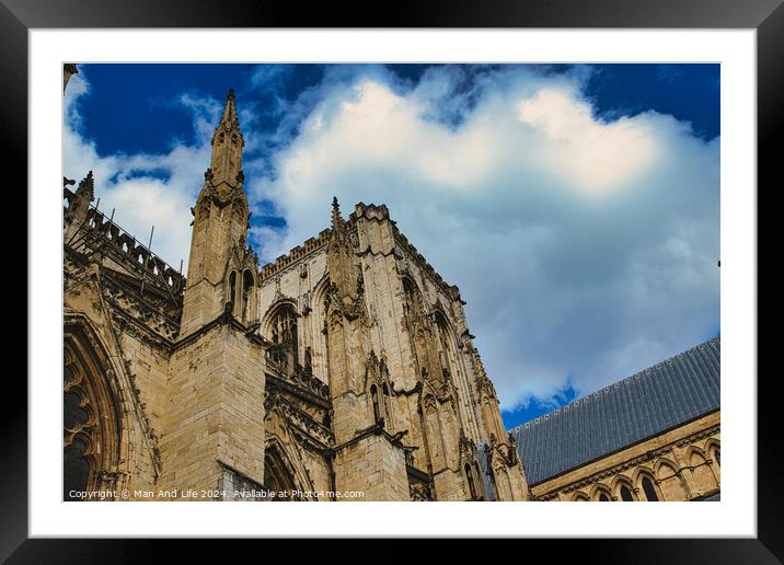 Majestic gothic cathedral facade against a dramatic sky with fluffy clouds, showcasing intricate architectural details and historical religious significance in York, North Yorkshire, England. Framed Mounted Print by Man And Life