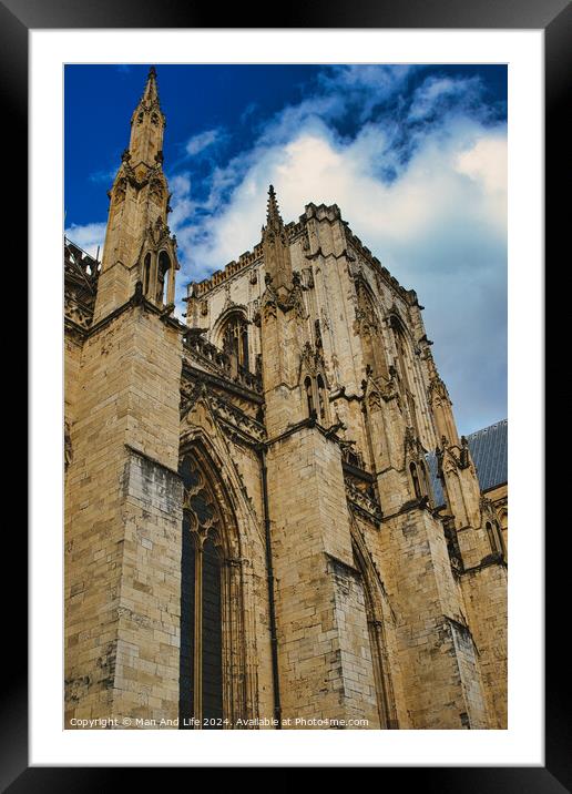 Gothic cathedral facade against a blue sky with clouds. The image captures the intricate architecture and towering spires of the historic religious building in York, North Yorkshire, England. Framed Mounted Print by Man And Life