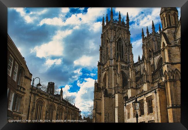 Dramatic sky over a majestic Gothic cathedral with intricate architecture, flanked by historic buildings, showcasing a blend of heritage and natural beauty in York, North Yorkshire, England. Framed Print by Man And Life