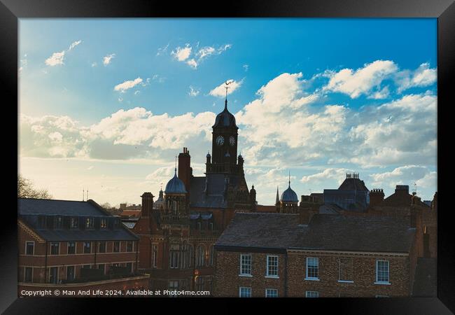 Vintage European architecture with a clock tower against a backdrop of a dramatic sky with fluffy clouds, capturing the essence of a historic town at sunset in York, North Yorkshire, England. Framed Print by Man And Life