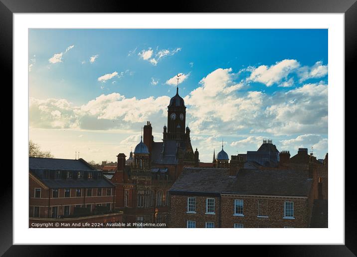 Vintage European architecture with a clock tower against a backdrop of a dramatic sky with fluffy clouds, capturing the essence of a historic town at sunset in York, North Yorkshire, England. Framed Mounted Print by Man And Life