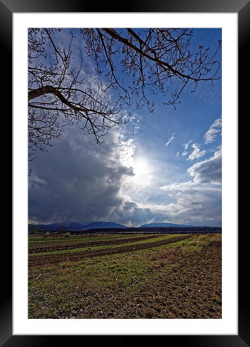 Spring plowing with angry clouds in the sky Framed Mounted Print by Adrian Bud