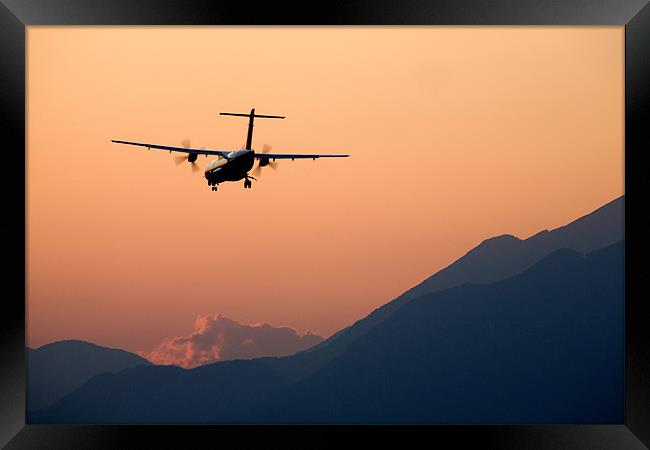 Airplane landing at sunset Framed Print by Ian Middleton
