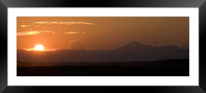 Light airplane landing at sunset on the solstice Framed Mounted Print by Ian Middleton