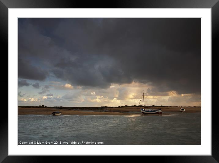 Storm over boats, Burnham Overy Staithe. Framed Mounted Print by Liam Grant