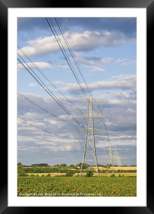 Evening light illuminating electricity pylons. Framed Mounted Print by Liam Grant