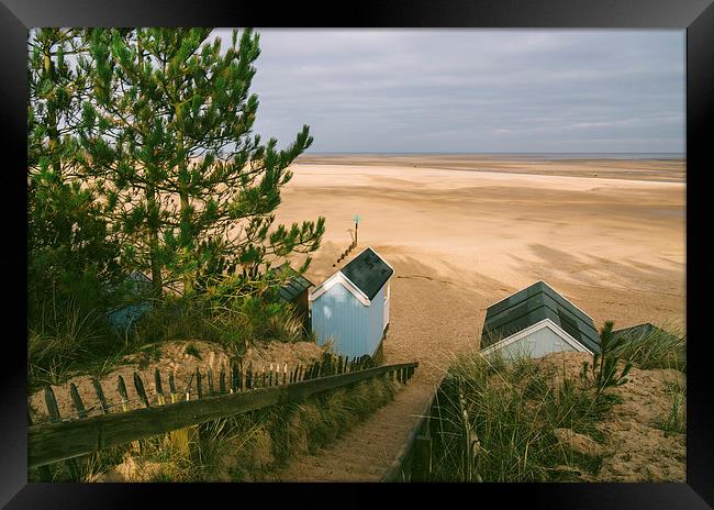 Beach huts, steps and sunlit view out to sea. Framed Print by Liam Grant