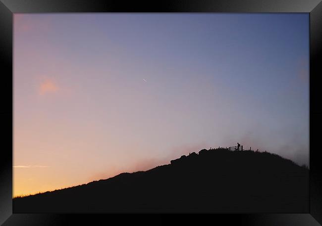 Male silhouetted on mountain top at sunset. Derbys Framed Print by Liam Grant