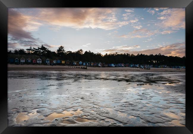 Sunset sky and beach huts reflected in a water at  Framed Print by Liam Grant