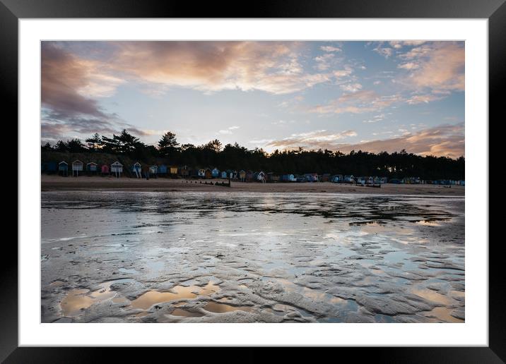 Sunset sky and beach huts reflected in a water at  Framed Mounted Print by Liam Grant