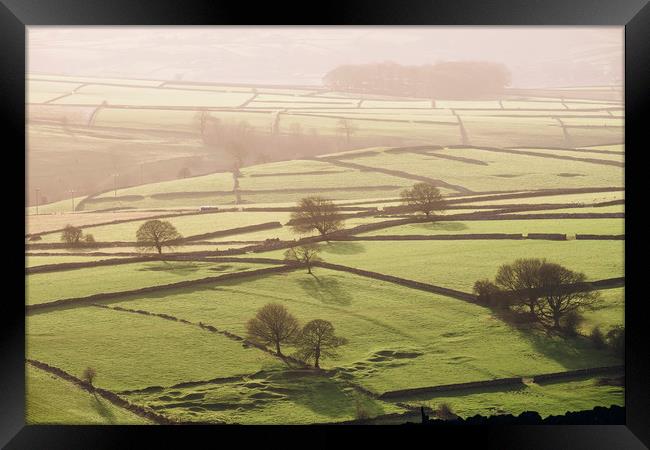 Hazy light at sunset over a valley of fields. Derb Framed Print by Liam Grant