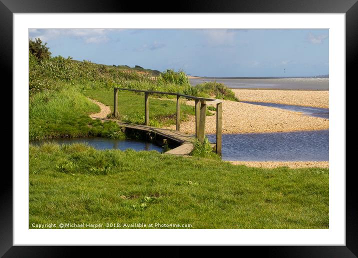 Footbridge across a small stream on a pebble beach Framed Mounted Print by Michael Harper
