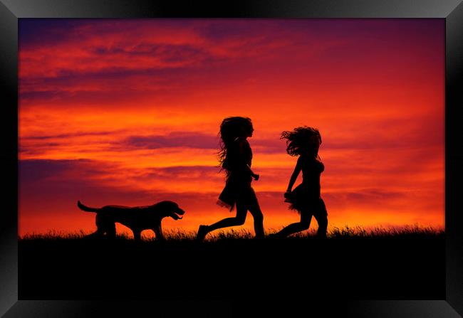 Two Girls and their dog running at sunset Framed Print by Maggie McCall