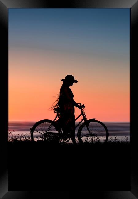 Silhouette Of Girl And Bike At Sunset Near The Sea Framed Print by Maggie McCall