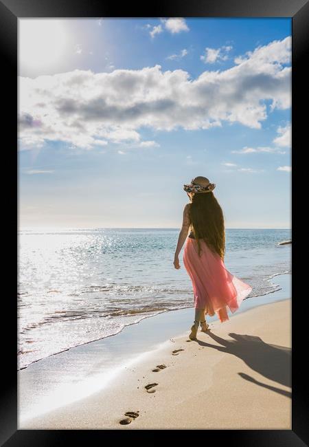 Rear view of a young woman on a beach Framed Print by Maggie McCall