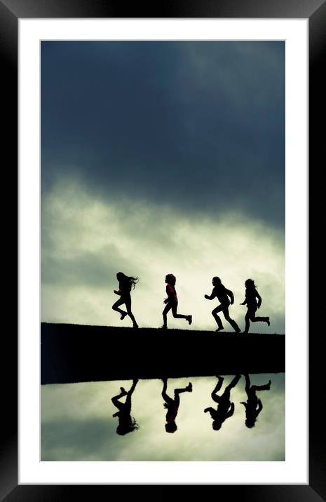 Reflection of Silhouetted girls Running. Framed Mounted Print by Maggie McCall