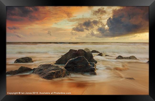 Sunset over the rocks Framed Print by Ian Jones