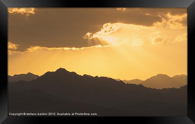 Sunlight through clouds at sunset over the Sinai d Framed Print by stefano baldini