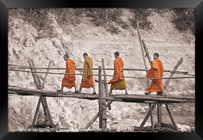 Buddhist monks across a bamboo bridge Framed Print by stefano baldini
