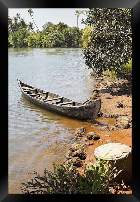 Canoe moored on sandy bank Framed Print by Arfabita  