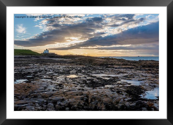 Bamburgh lighthouse from Harkness Rocks sunset Framed Mounted Print by Graham Moore