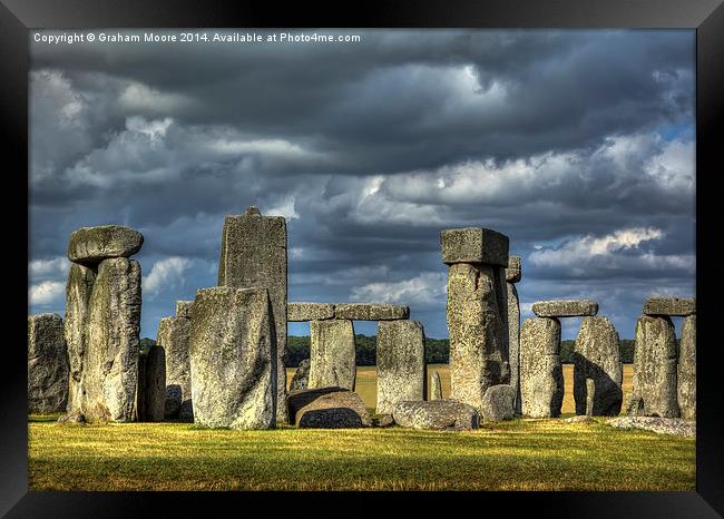 Stonehenge in gathering storm Framed Print by Graham Moore