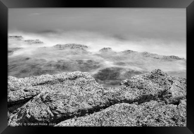 Waves on rocks monochrome Framed Print by Graham Moore