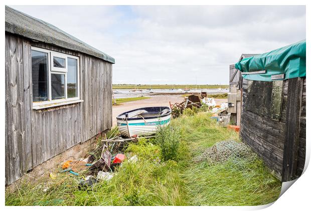 Fishing boat between fishing huts at Brancaster Staithe Print by Jason Wells