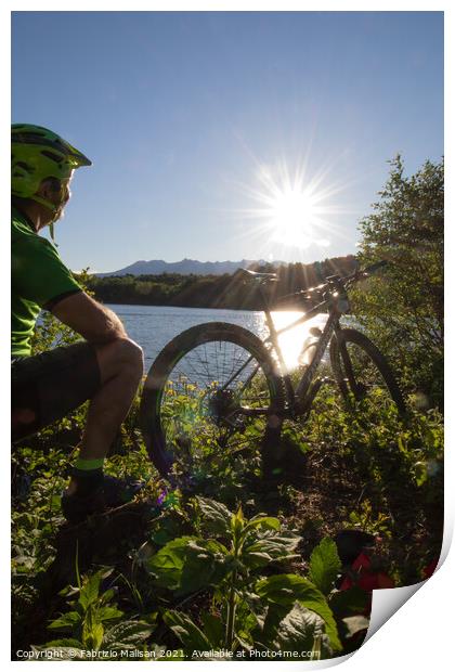 Mountain biking at sunset by the lake Print by Fabrizio Malisan