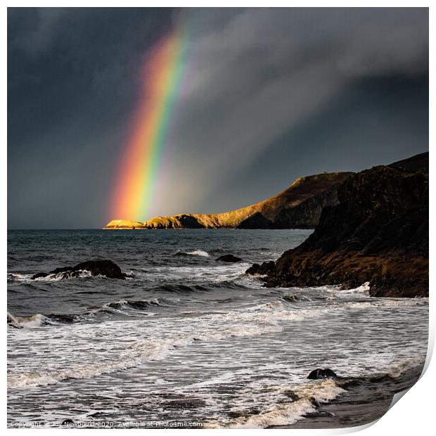 Rainbow light on headland at Cardigan Bay Print by Joy Newbould