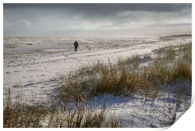 Person walking on a snowy beach Print by GILL KENNETT