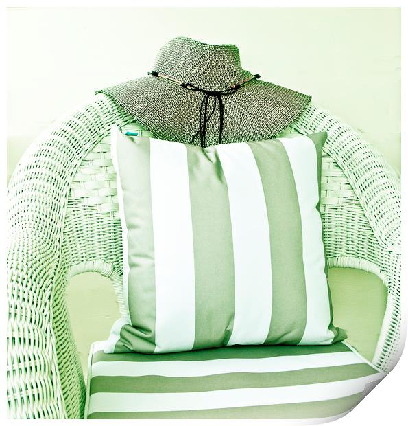 Hat on wicker chair with cushion Print by David Bigwood